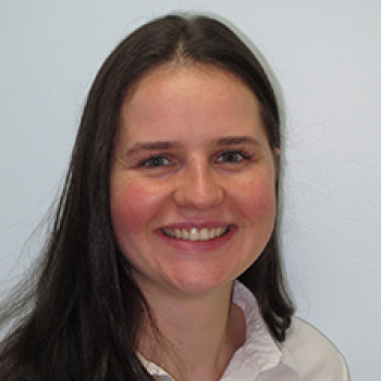 Young woman smiling at camera, professional headshot against white background for orthodontics practice.